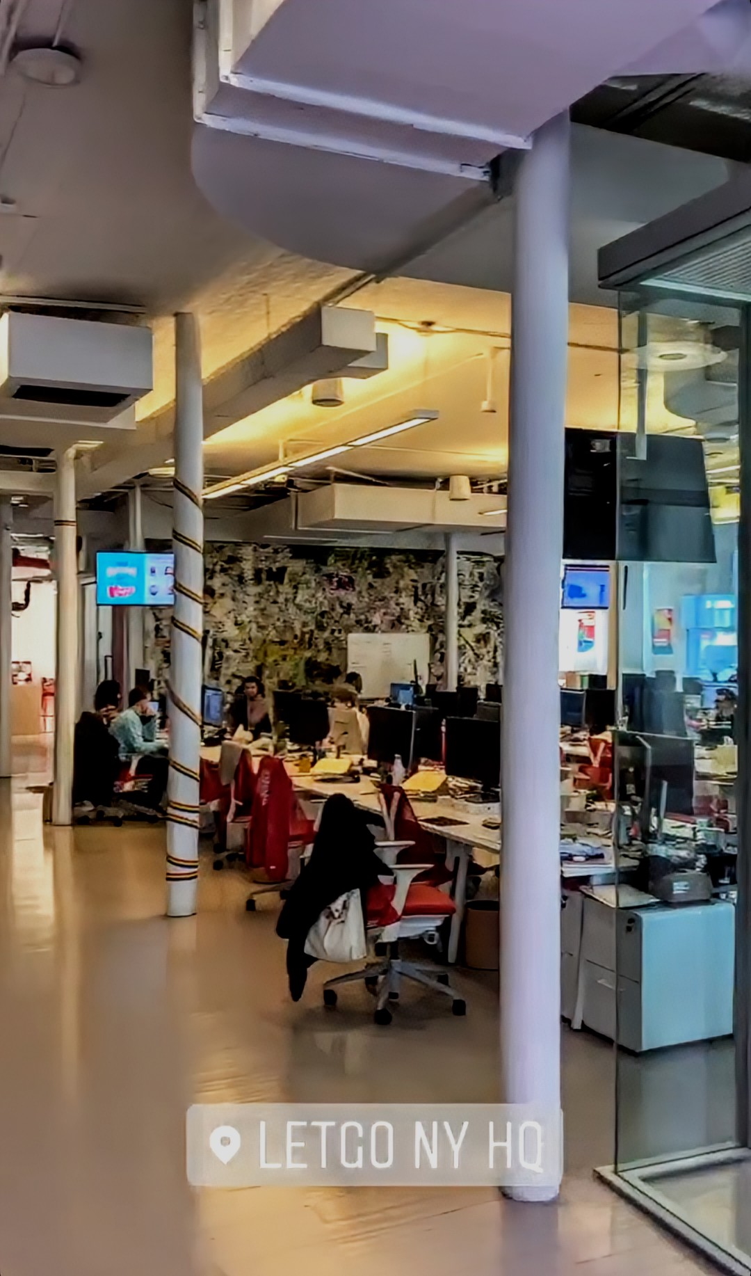 Hand with smartwatch pointing at vertical monitor with code